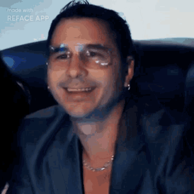a man wearing glasses and a necklace is smiling in a video made with reface app