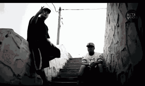 a black and white photo of two men with alta voce written on the bottom right corner