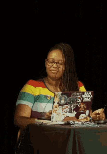 a woman sits at a table with a laptop that says dious ban digital talk on it