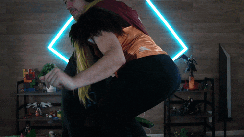 a man is carrying a woman on his back in front of a shelf full of action figures