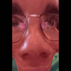 a close up of a person wearing glasses and making a face