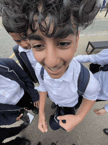 a boy with braces on his teeth smiles while standing in a crowd of people