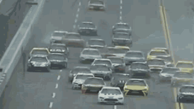 a bunch of cars are driving down a road and one of them has the word ford on the side