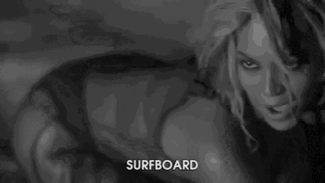 a black and white photo of a woman with the word surfboard on the bottom right