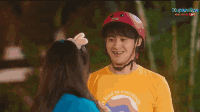 a man in a yellow shirt is standing next to a woman in a blue sweater