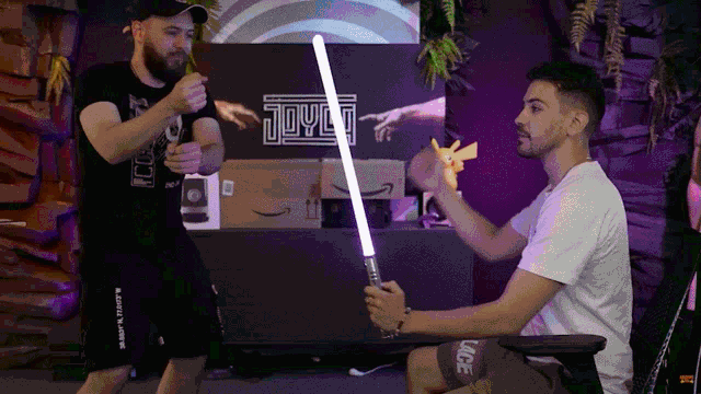 a man holding a light saber in front of a sign that says joyo