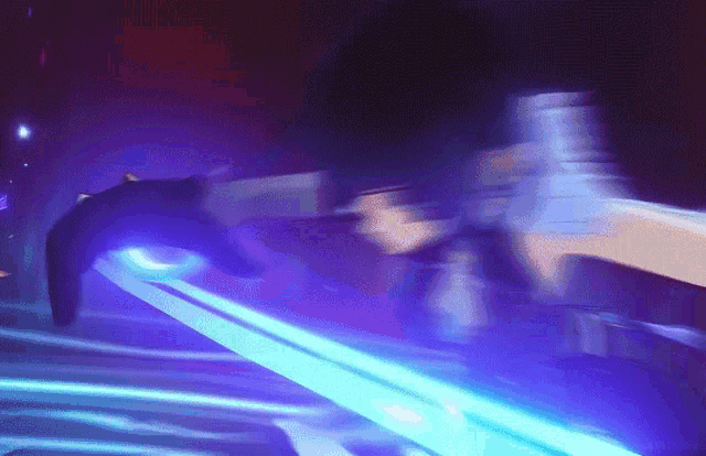 a blurry picture of a person holding a sword with a purple light coming out of it .