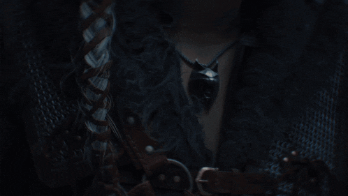 a close up of a woman 's face with a sword in the background