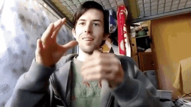 a man wearing a shirt that says dw is making a gesture