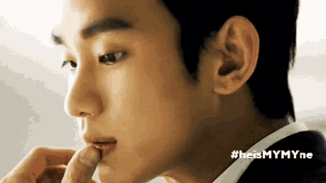 a close up of a man 's face with his finger in his mouth