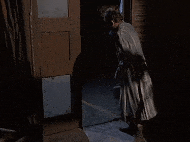 a man in a robe is standing in a dark room