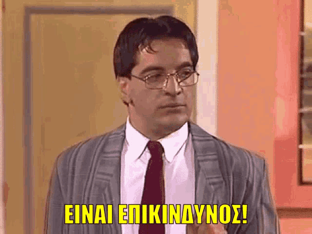 a man in a suit and tie is making a funny face with the words einai epikindynos written above him