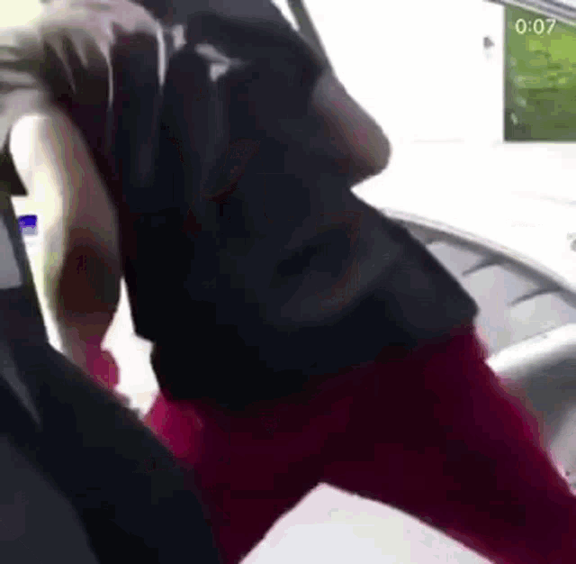 a man in a black shirt and red pants is standing next to another man in a black shirt .