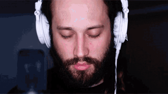 a man with a beard wearing white headphones