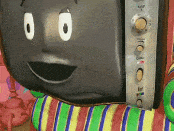 a television with a face on it is sitting on a striped chair