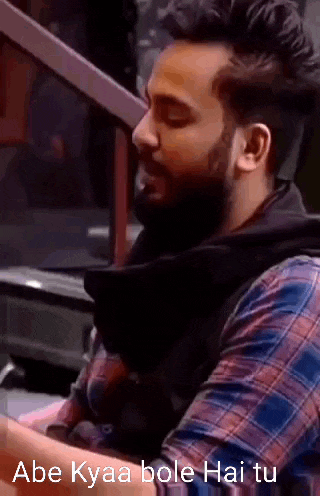 a man with a beard wearing a plaid shirt is sitting in a car .