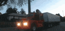 a red semi truck is driving down a street