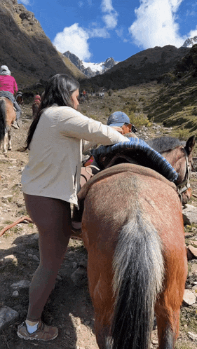 a woman is putting a blanket on a horse