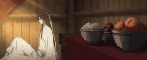 a woman is sitting in front of a table with bowls of fruit and rice .