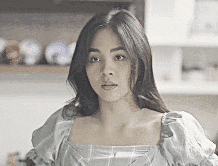 a woman in a blue plaid top is looking at the camera .