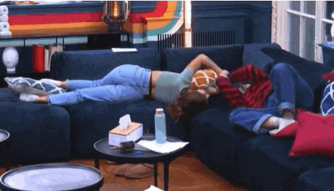 a man and a woman are laying on a couch in a living room .
