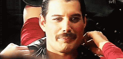 a man with a mustache is being touched by a woman 's hand