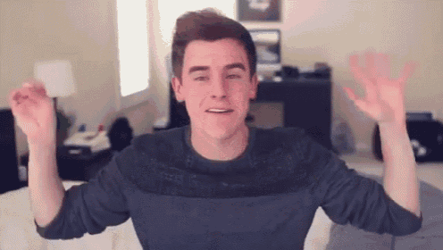 a young man in a striped sweater is waving his arms in the air