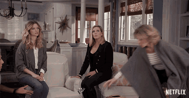three women sit on a couch in a living room with a netflix logo in the corner