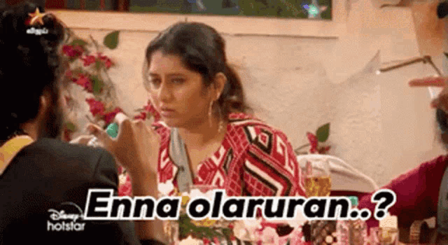 a woman is sitting at a table talking to a man with the words enna olaruran on the bottom