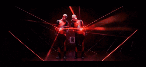 a couple of people are dancing in a dark room with red lights