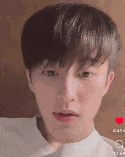 a close up of a young man 's face with a white shirt on making a funny face .