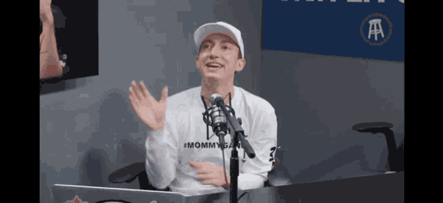 a man wearing a white hat and a white shirt that says #mommygain