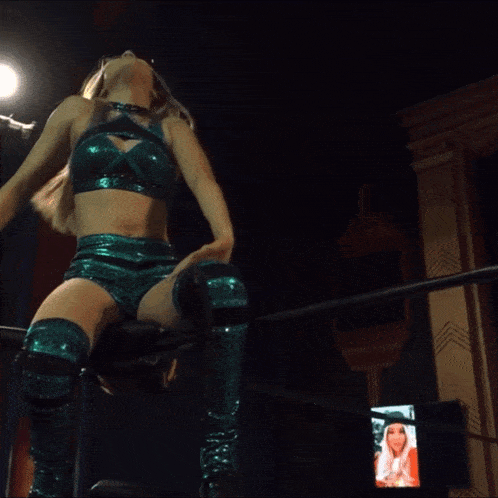 a woman in a wrestling ring with a picture of her on the screen