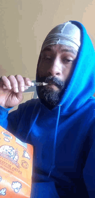 a man wearing a blue hoodie is eating popcorn