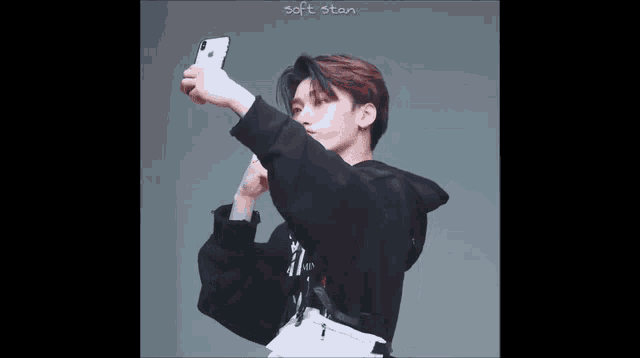 a young man is taking a selfie with a cell phone .