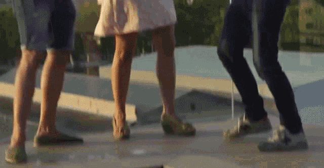 a group of people are dancing on a rooftop with their legs crossed .