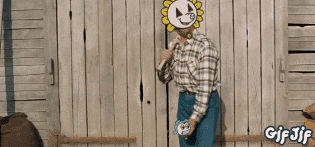 a man in a plaid shirt is standing in front of a wooden fence with a gif jif watermark