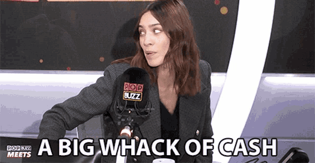 a woman in front of a microphone that says pop buzz