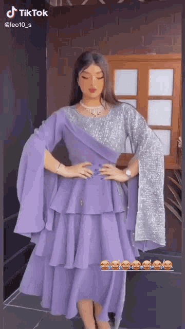 a woman is wearing a purple dress with silver sequins