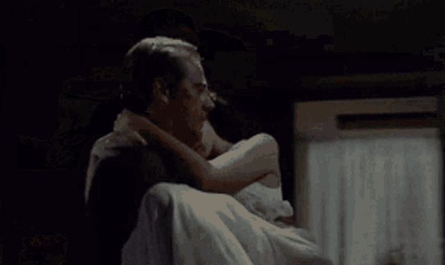 a man is carrying a woman in a white dress
