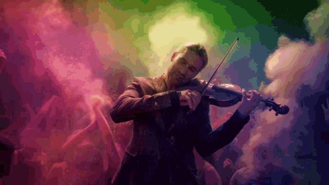 a man playing a violin in front of a crowd of people