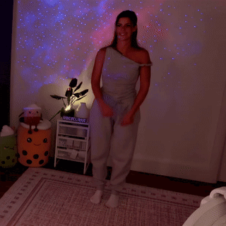 a woman is dancing in a room with a sign that says ' epoch ' on it