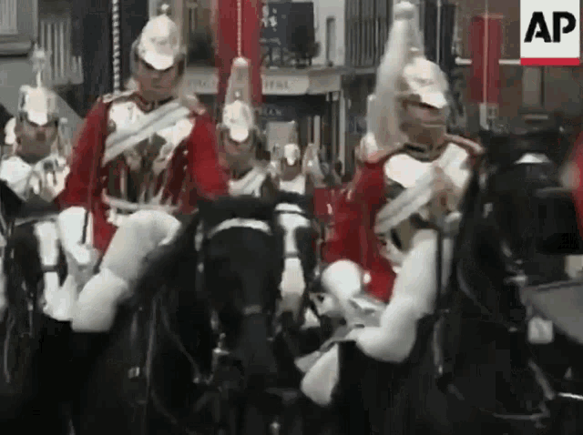 a group of men in military uniforms are riding horses in a parade sponsored by the ap