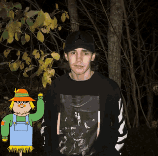 a scarecrow is standing next to a man wearing a black sweater