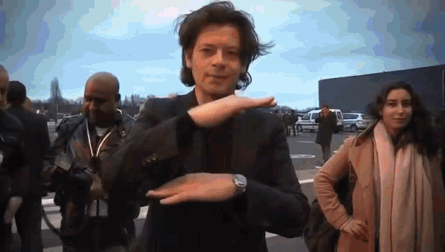 a man in a suit is dancing in front of a group of people .