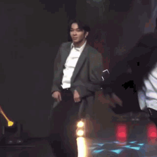 a man in a suit is dancing on stage