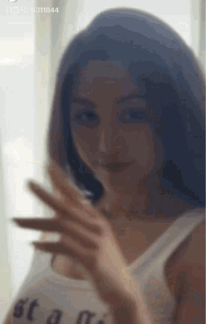 a blurry photo of a woman with the number 6311844 on the bottom right