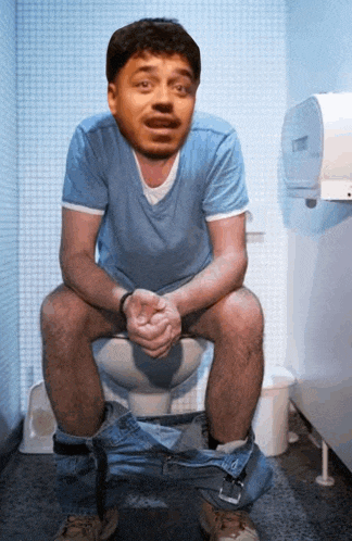 a man sits on a toilet with his pants down