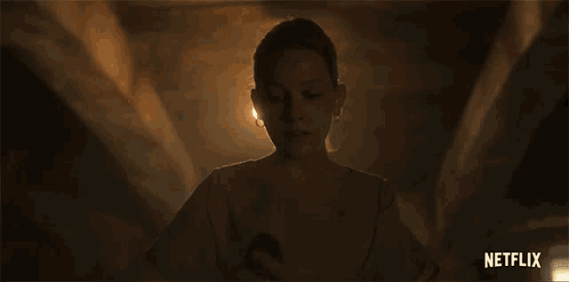 a woman is looking up in a dark room with netflix written on the bottom