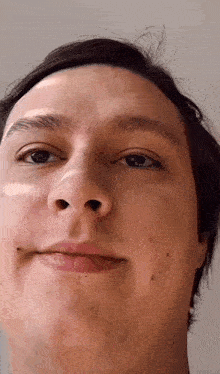 a close up of a man 's face with a slight smile